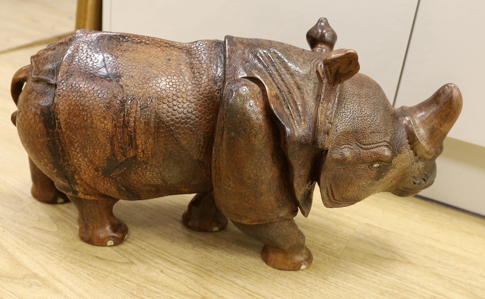 A carved wooden model of a rhinoceros, approximately 60cms long